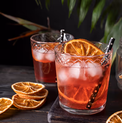 Red cocktails with ice and dried orange slices