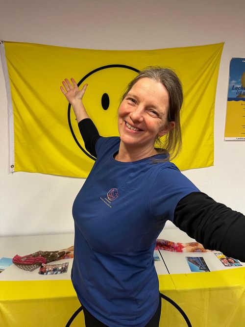 Frau die Arme ausbreitet und lacht