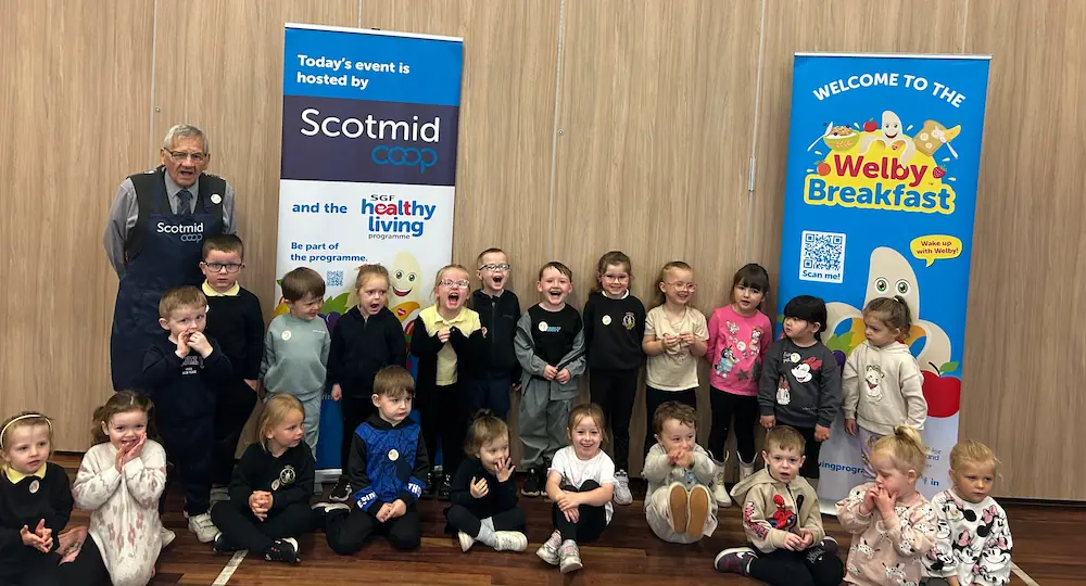 Logan Primary School pupils at a Welby Breakfast event with Scotmid banners