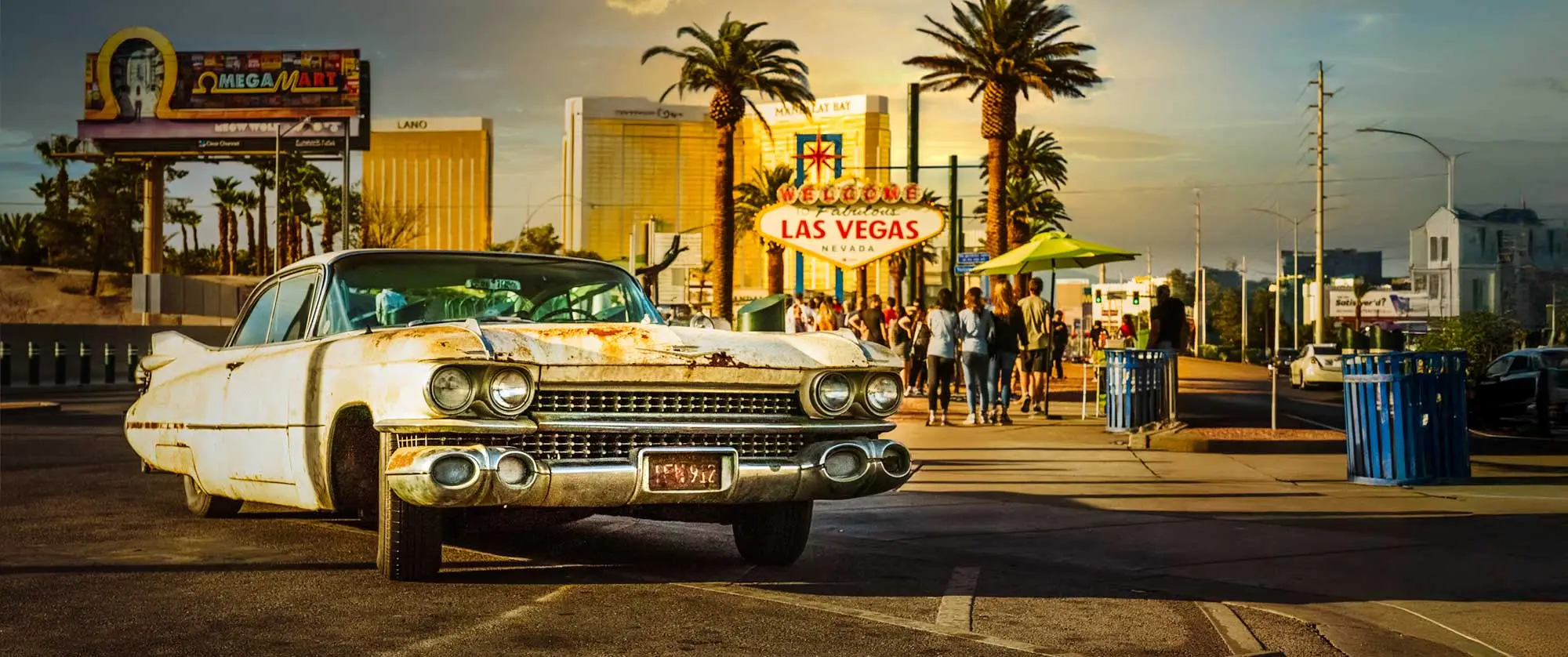 A rusty vintage car parked near the iconic "Welcome to Fabulous Las Vegas" sign, with palm trees, people, and city buildings in the background.