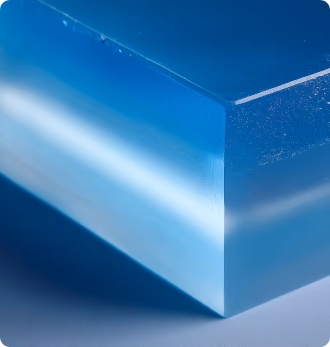 Close-up of a blue translucent rectangular block with smooth edges on a gray surface.