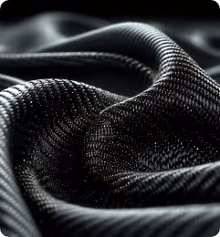 Close-up of textured black fabric with a woven pattern, showing folds and light reflections.