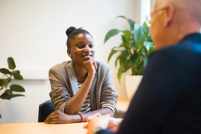 Une jeune femme noire sourit à son mentor avec le mentor posé sur sa main
