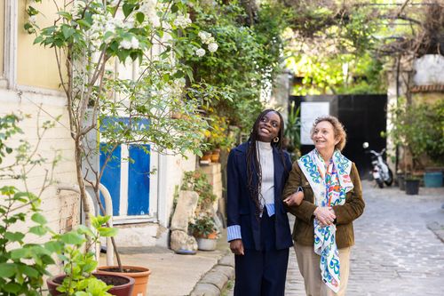 un jeune homme noir tapant dans la main d'une dame plus âgée au teint hâlé en souriant