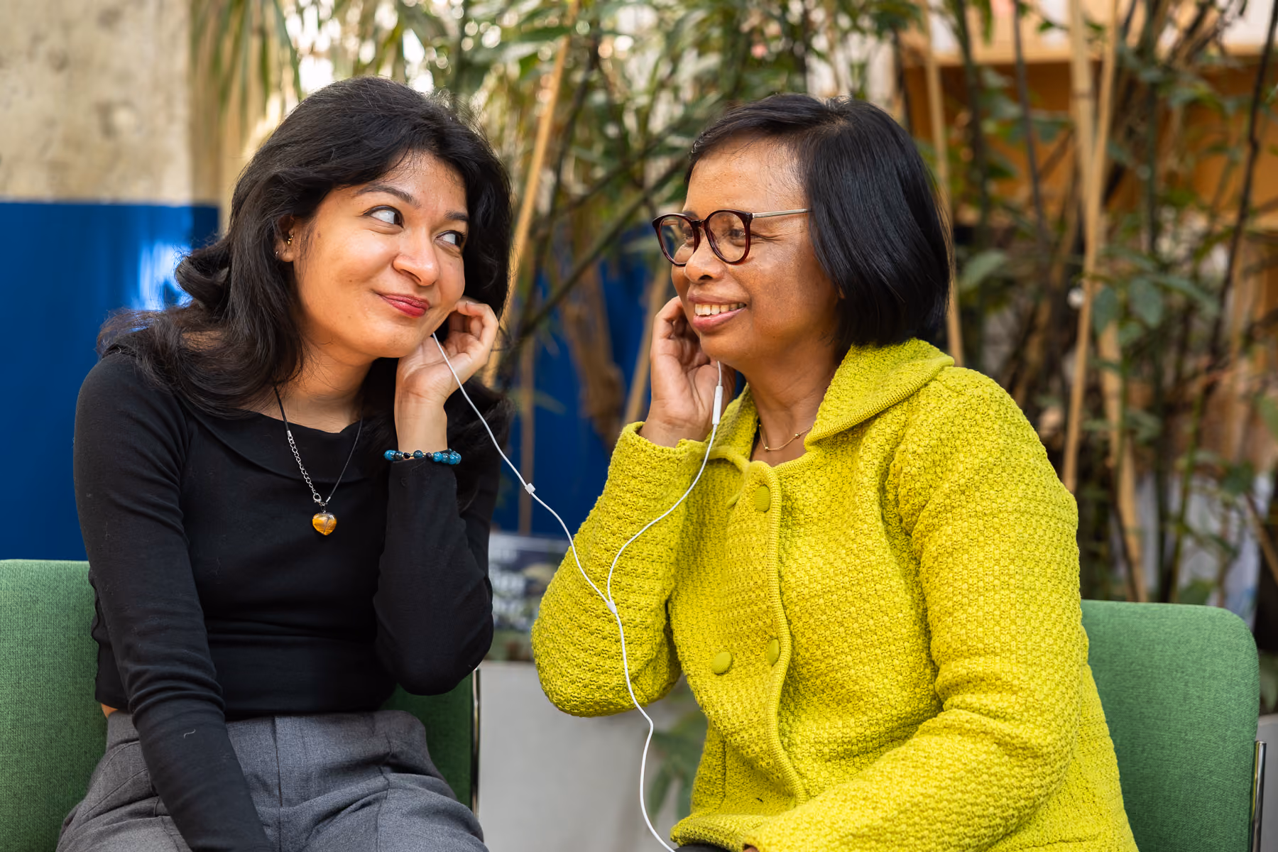 Une jeune femme noire pose avec un grand sourire aux côtés de son mentor un homme aux cheveux blancs avec des lunettes