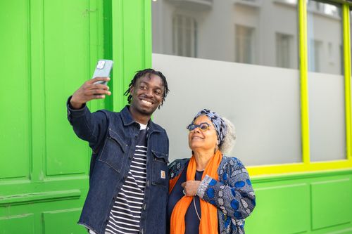Une jeune femme discute dans une pièce avec sa mentor une dame plus âgée avec des cheveux blonds. Elles sont assises autour d'une petite table blanche.