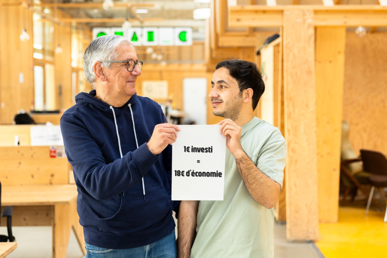 Un groupe de 4 personnes pose sur la terrasse d'un café, de droite à gauche, il y a un jeune homme avec des nattes assis sur le dos d'une chaise, un homme blanc de plus de 50 ans avec un pull rose qui s'appuie sur le premier. Ensuite une dame coupe courte et pull bleu dont l'épaule touche l'épaule de la dernière jeune femme à la peau foncée et de longues tresses