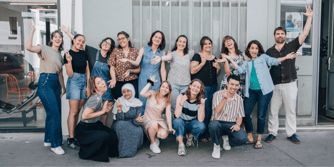 Photo de l'équipe de DUO Anvers, un groupe de personnes le long d'un mur extérieur qui se sourient et rigolent ensemble