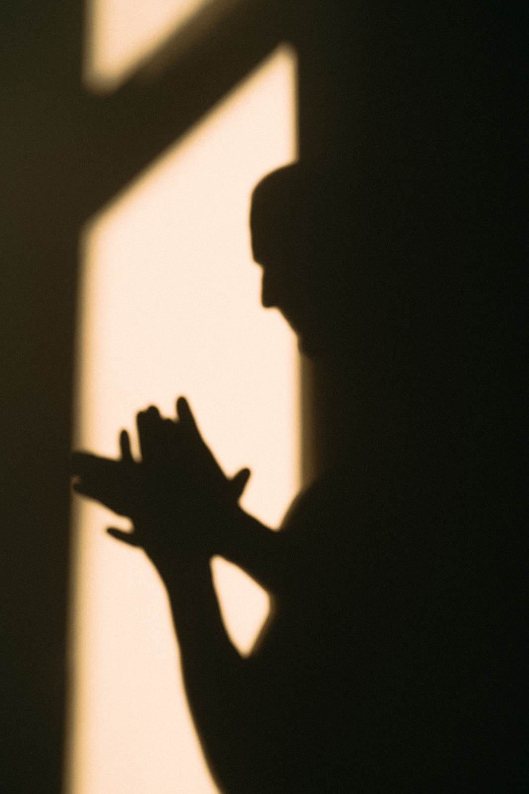 Ein Schatten zeigt einen Mann. Er reibt seine Hände aneinander. 