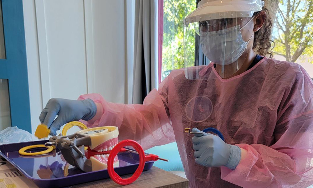 Dental assistant student working with equipment
