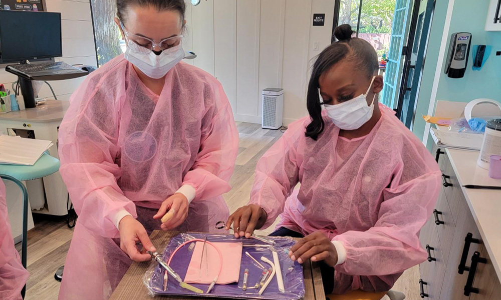 Dental assistant students working with equipment