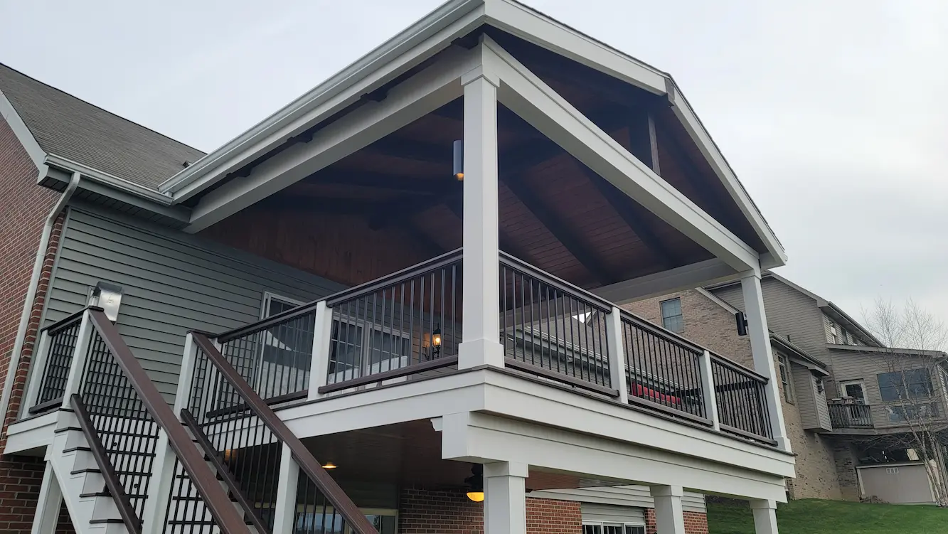 Covered backyard deck with composite decking, finished ceiling, pvc trim, and lighting.