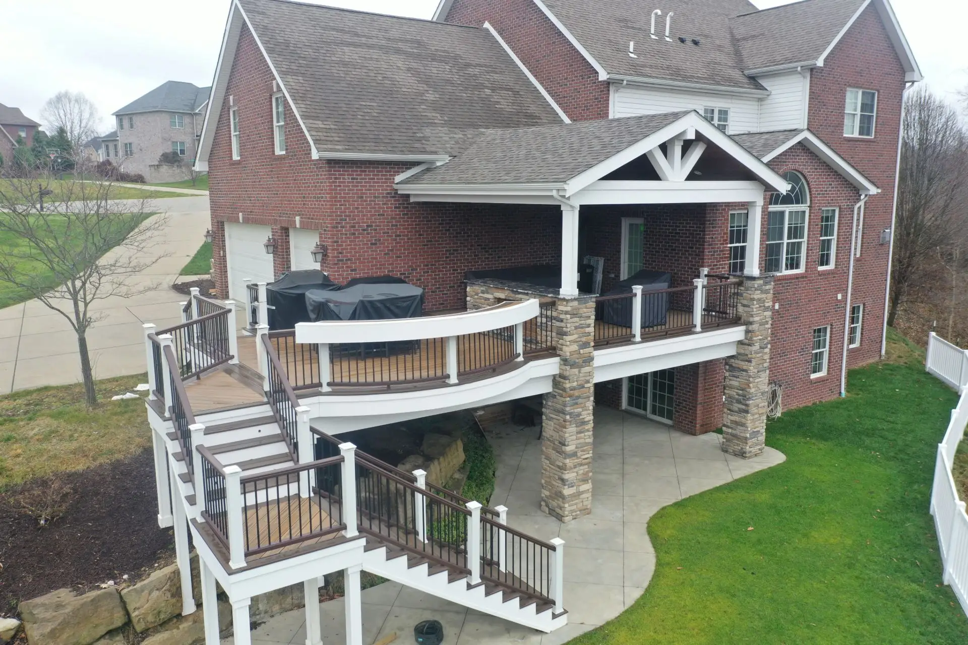 Covered deck with custom curved handrail and outdoor kitchen in Sewickley