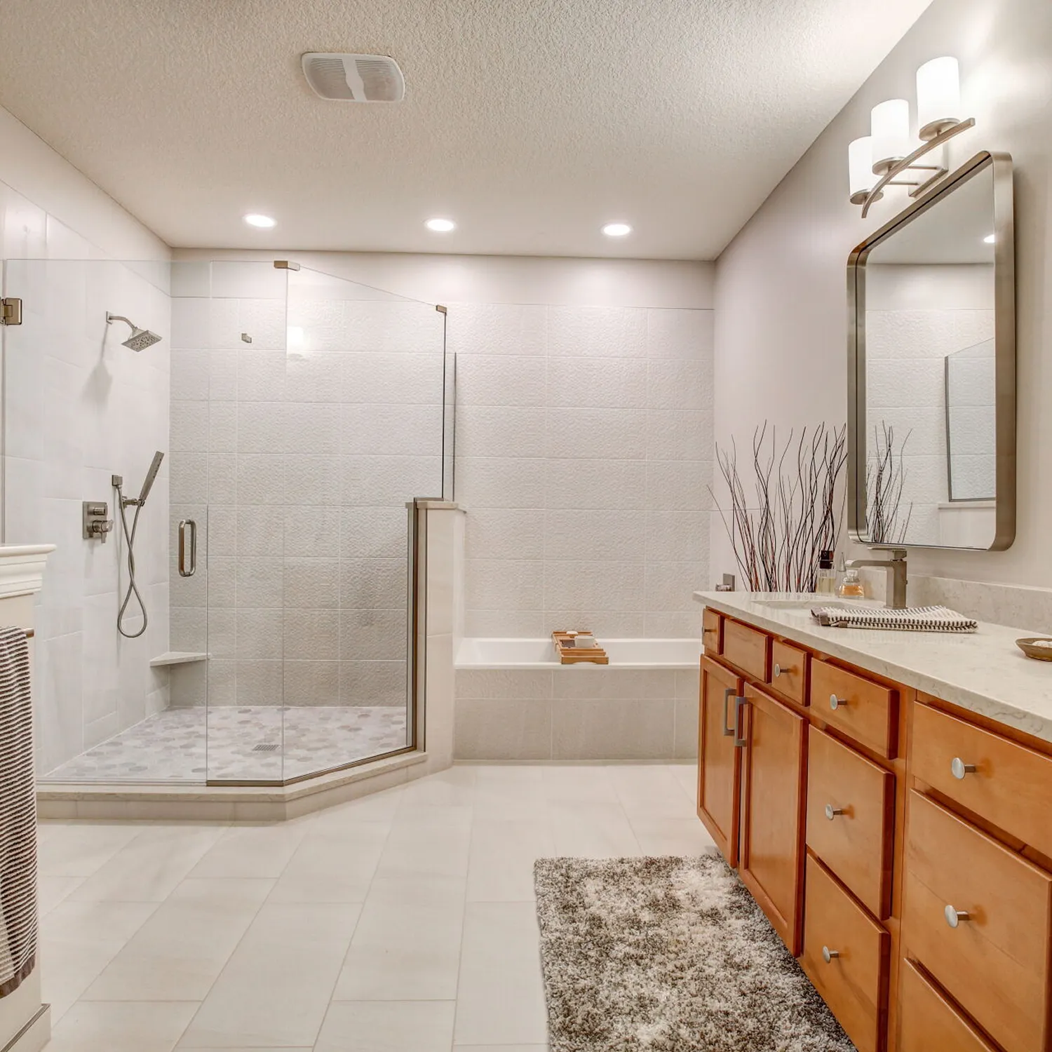 Bathroom electrical remodel with updated vanity lighting and glass shower enclosure.