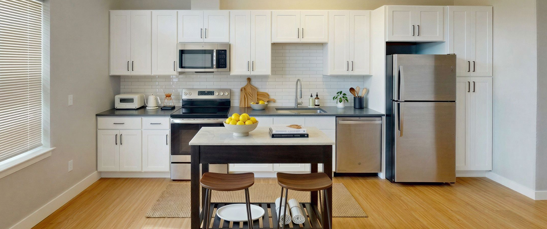 Studio apartment kitchen with island seating and stainless steel appliances