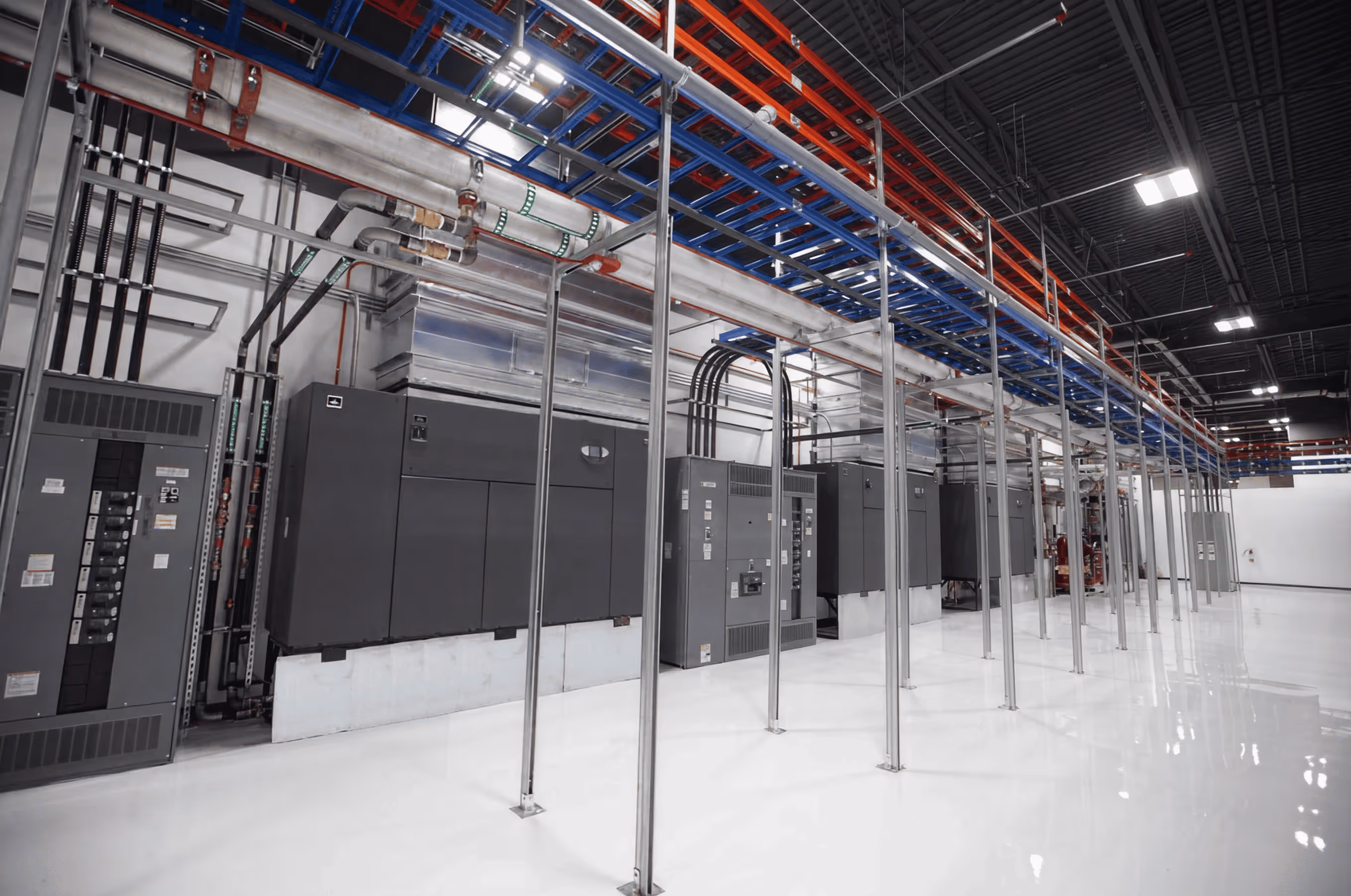 Industrial room with electrical panels, pipes, and metal framework on a shiny white floor.
