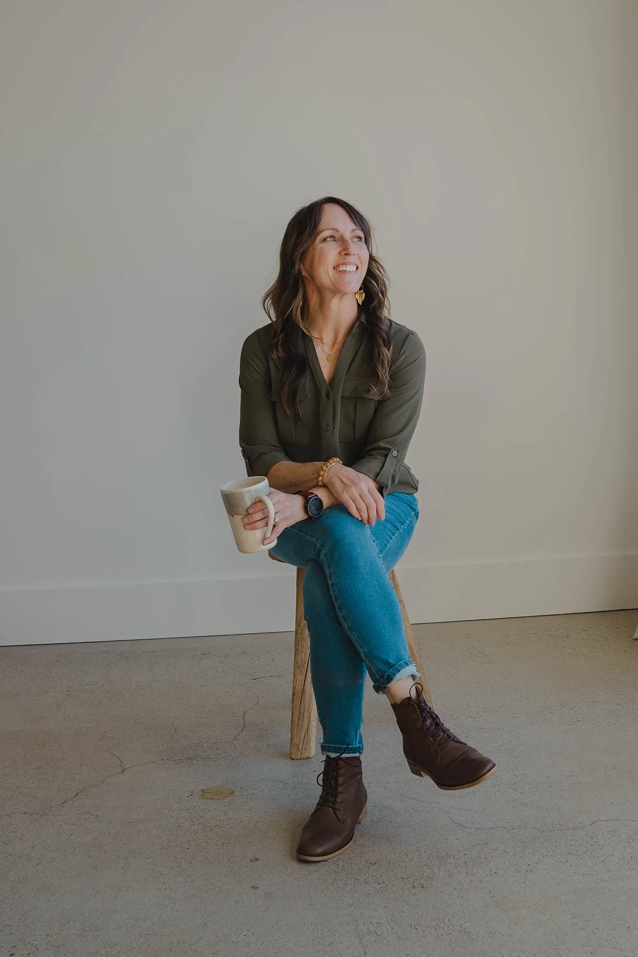 Andi Giachetti, nurse practitioner, owner of Functional Reset NP sitting at a desk with a potted tree behind her.
