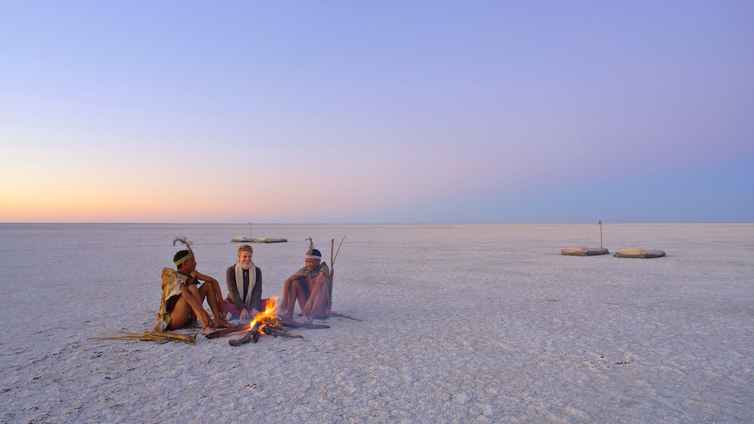 Gæsterne sidder sammen med San-folket i Makgadikgadi Salt Pans på en luksussafari i Botswana.