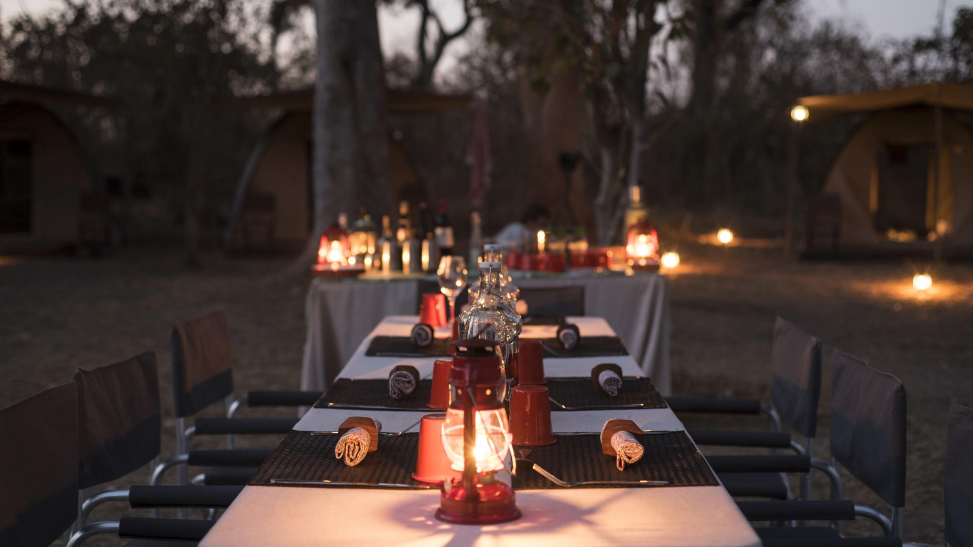 Lanterneoplyst bushmiddag under stjernerne i en luksuriøs mobil safaricamp i Botswana.