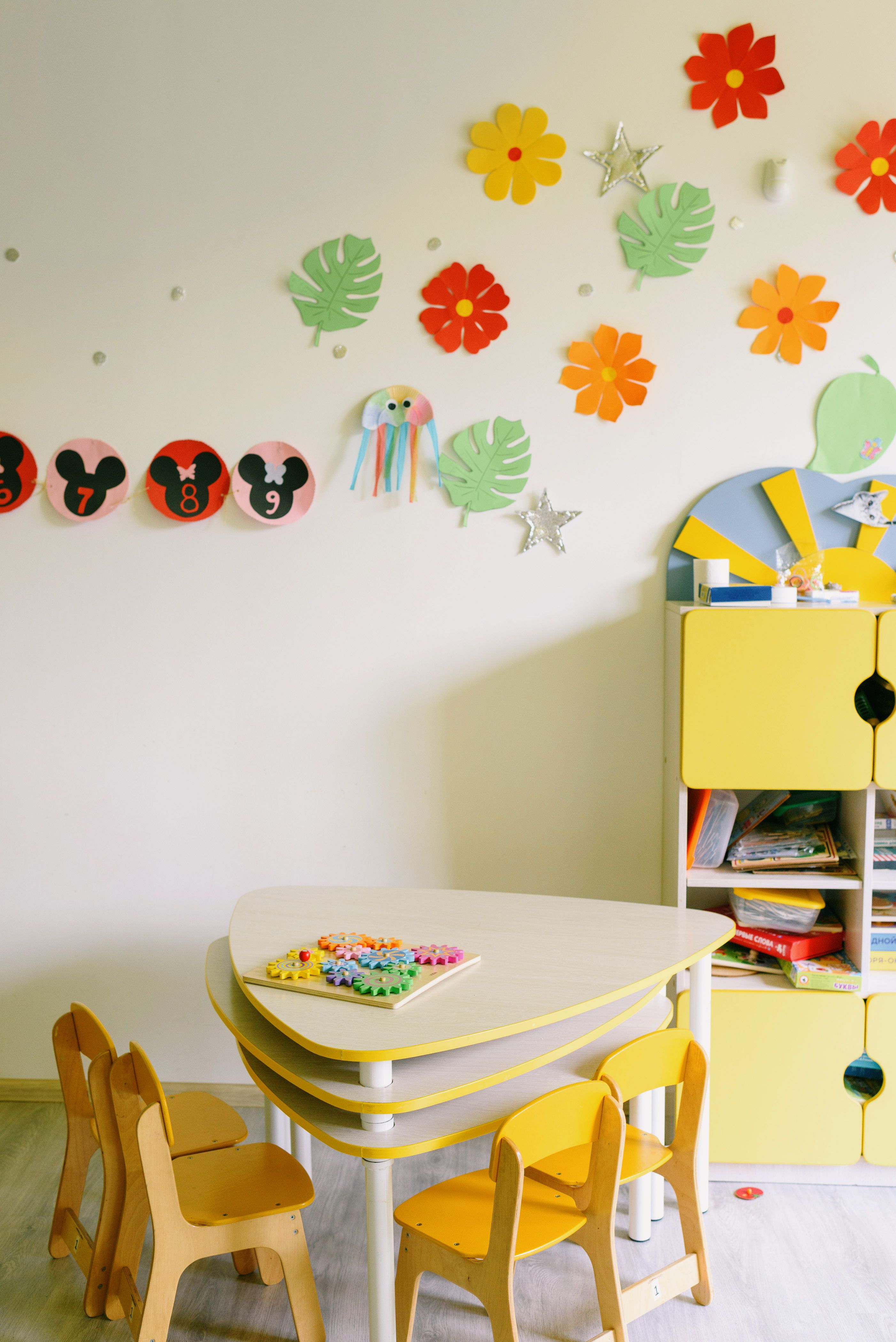 Brightly decorated children's classroom with colorful crafts and furniture.