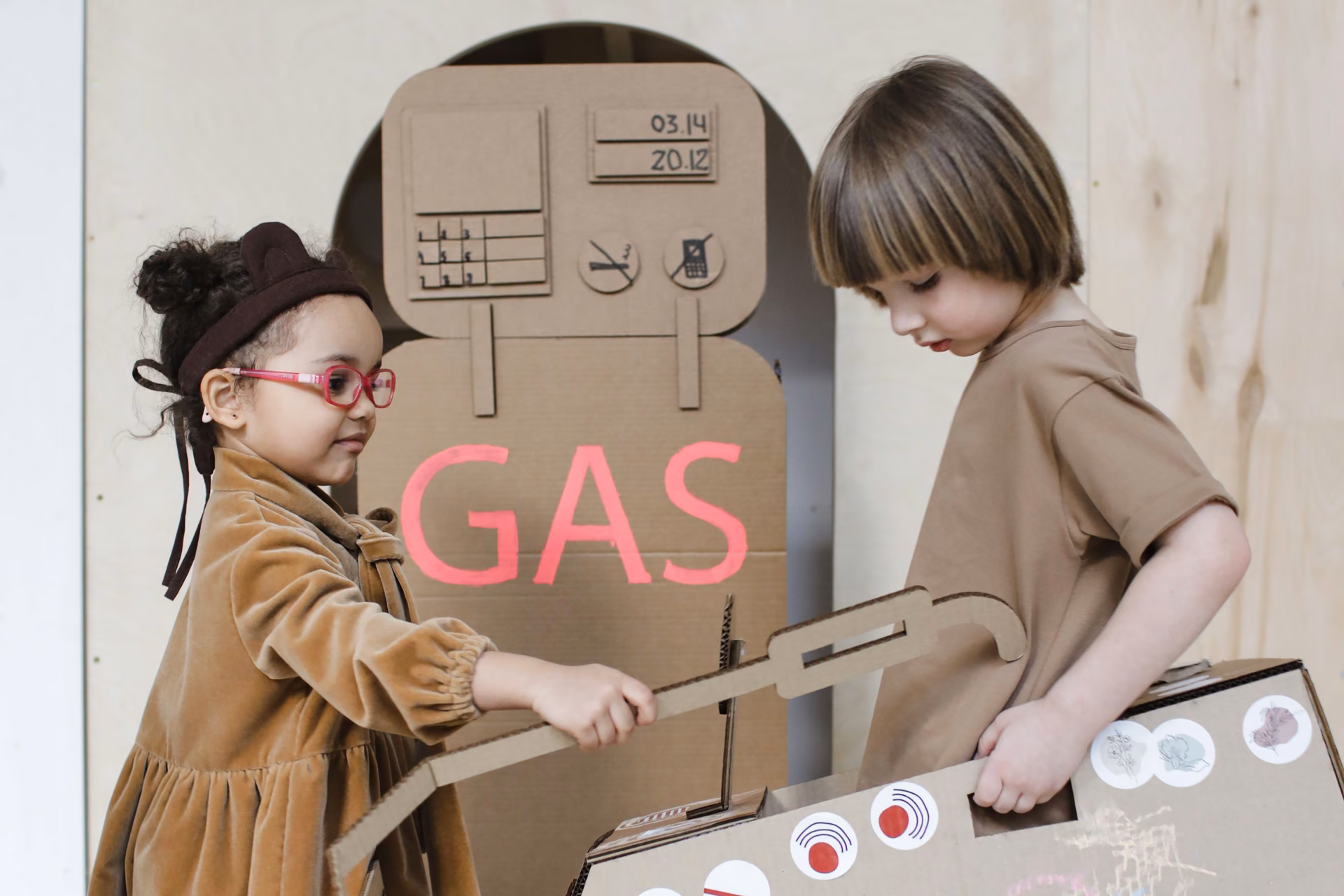 Two children playing together with DIY cardboard box toys