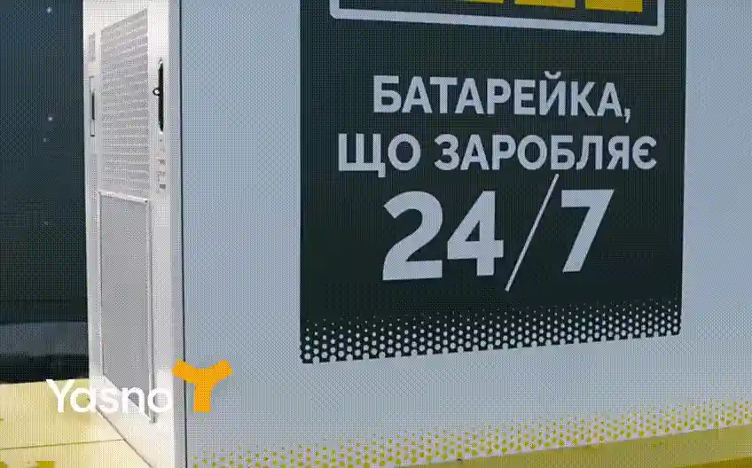Крупний план рекламної дошки з текстом батарейка, що заробляє 24/7 біля білого корпусу обладнання.