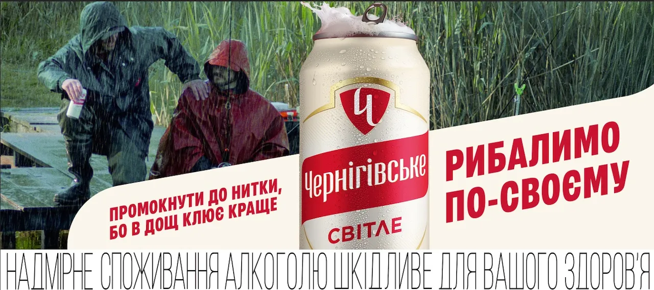 Чотири банки пива Чернігівське різних видів стоять на траві на стадіоні.