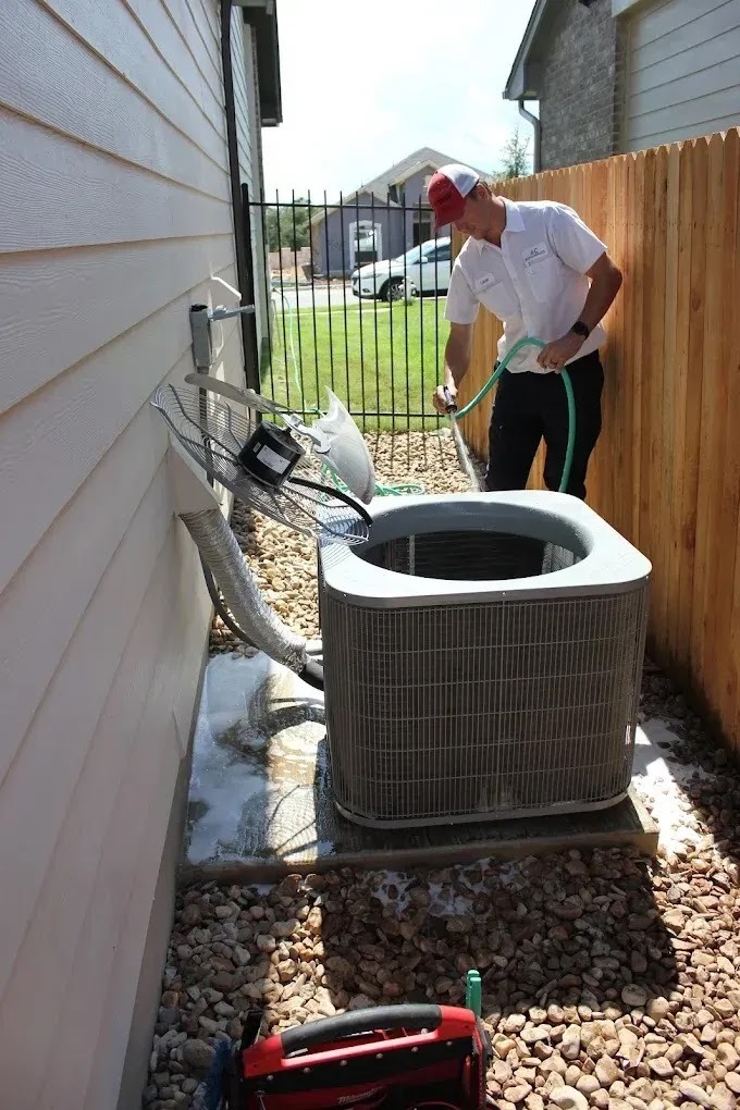 Technician inspecting HVAC system for reliability enhancements