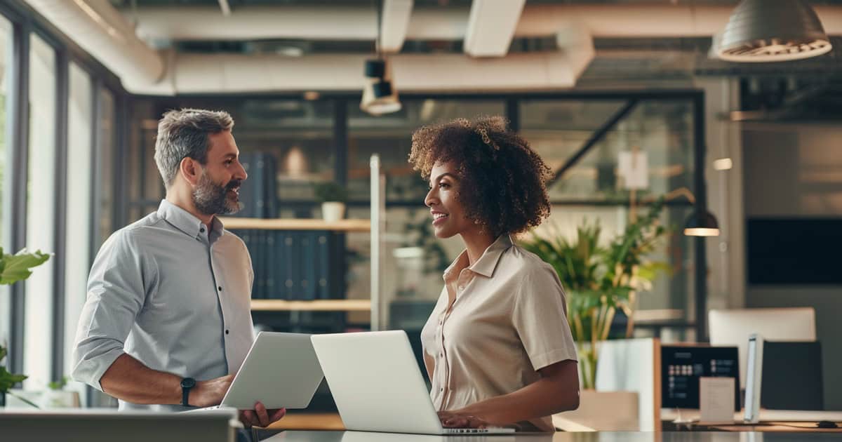 Small business team collaborating in a workspace with cloud-based tools displayed on monitors.