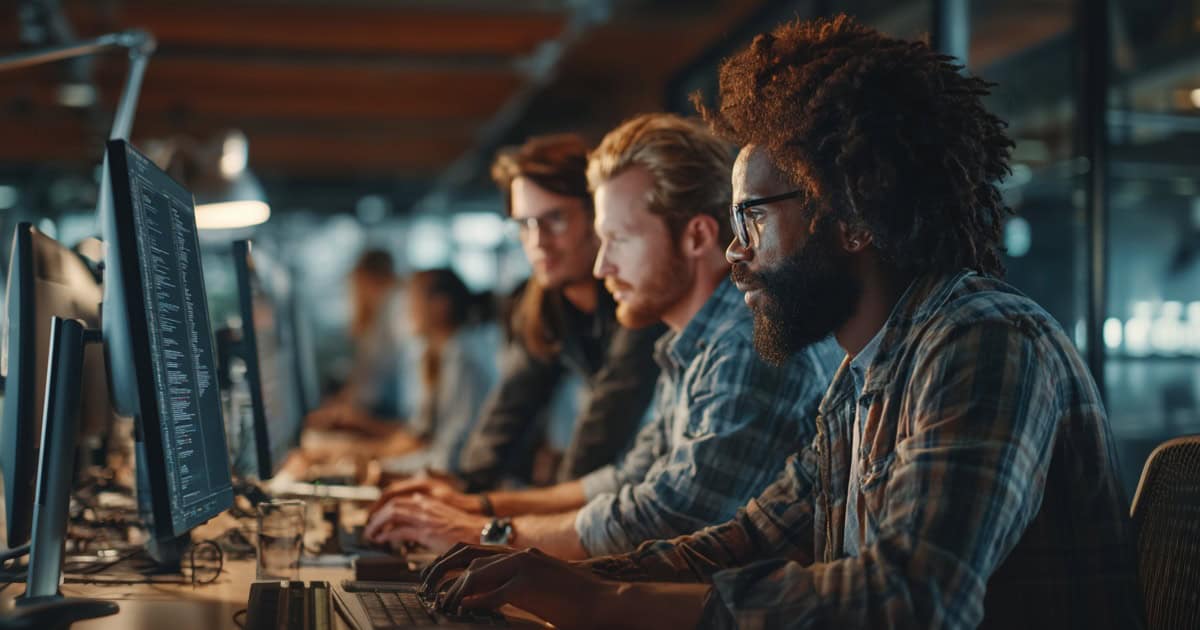 Financial professionals working with an IT specialist to review secure systems and support business operations.