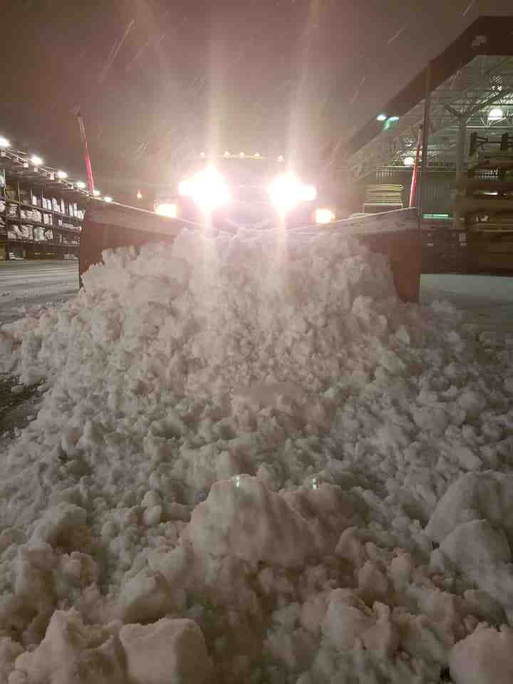 snow plow clearing large commercial parking lot at night - commercial snow plowing delaware oh