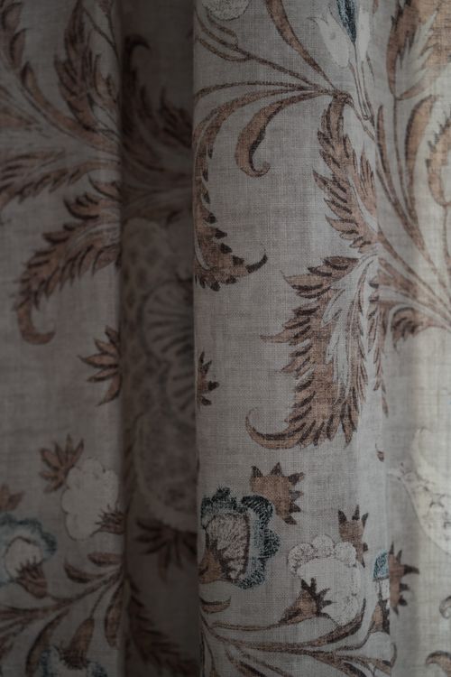 Close-up of vintage floral linen curtain with elegant neutral tones — refined country interior design.