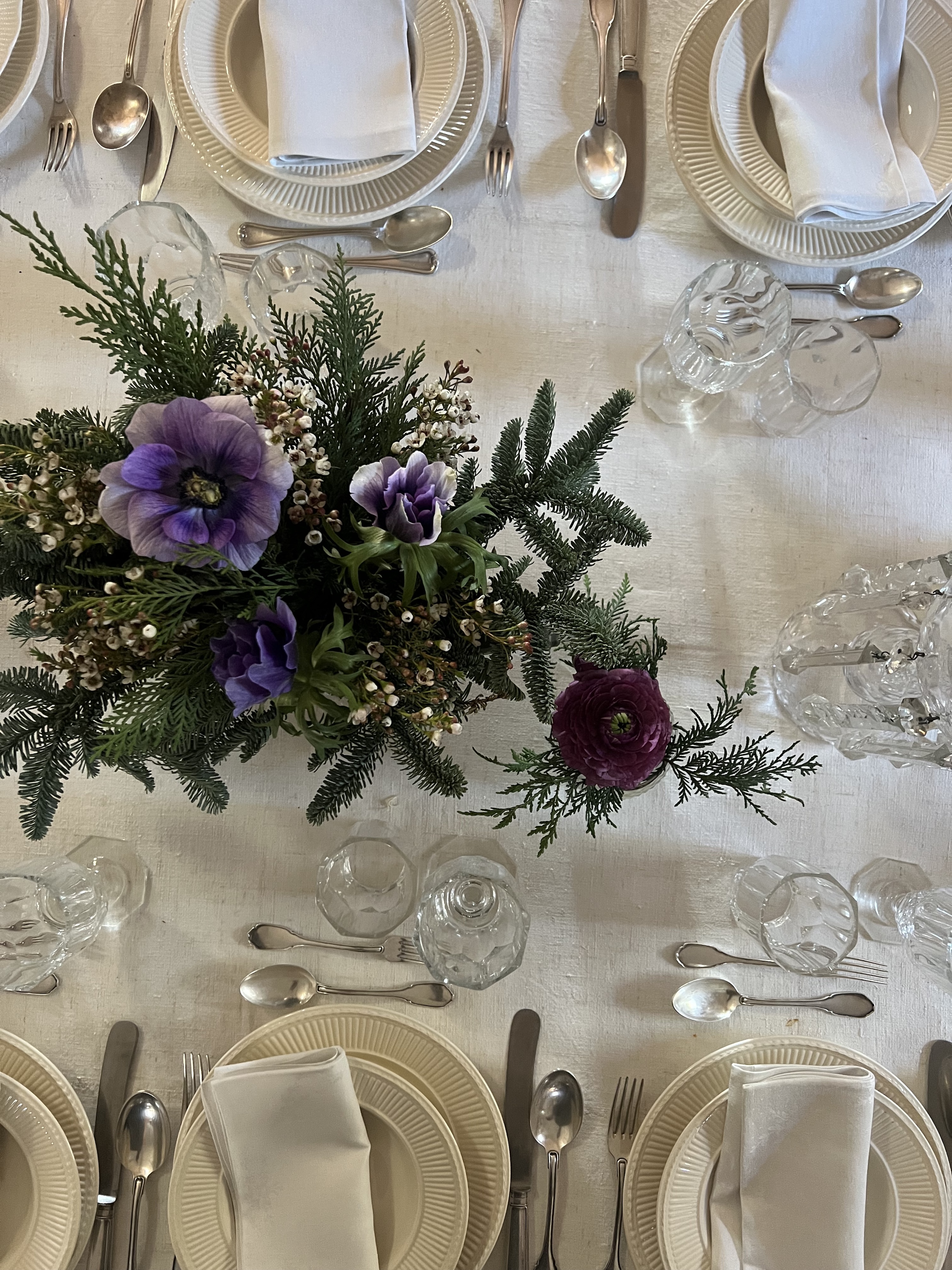 Table set with ivory ceramics and floral centerpiece, prepared for an elegant Italian cooking class dining experience.