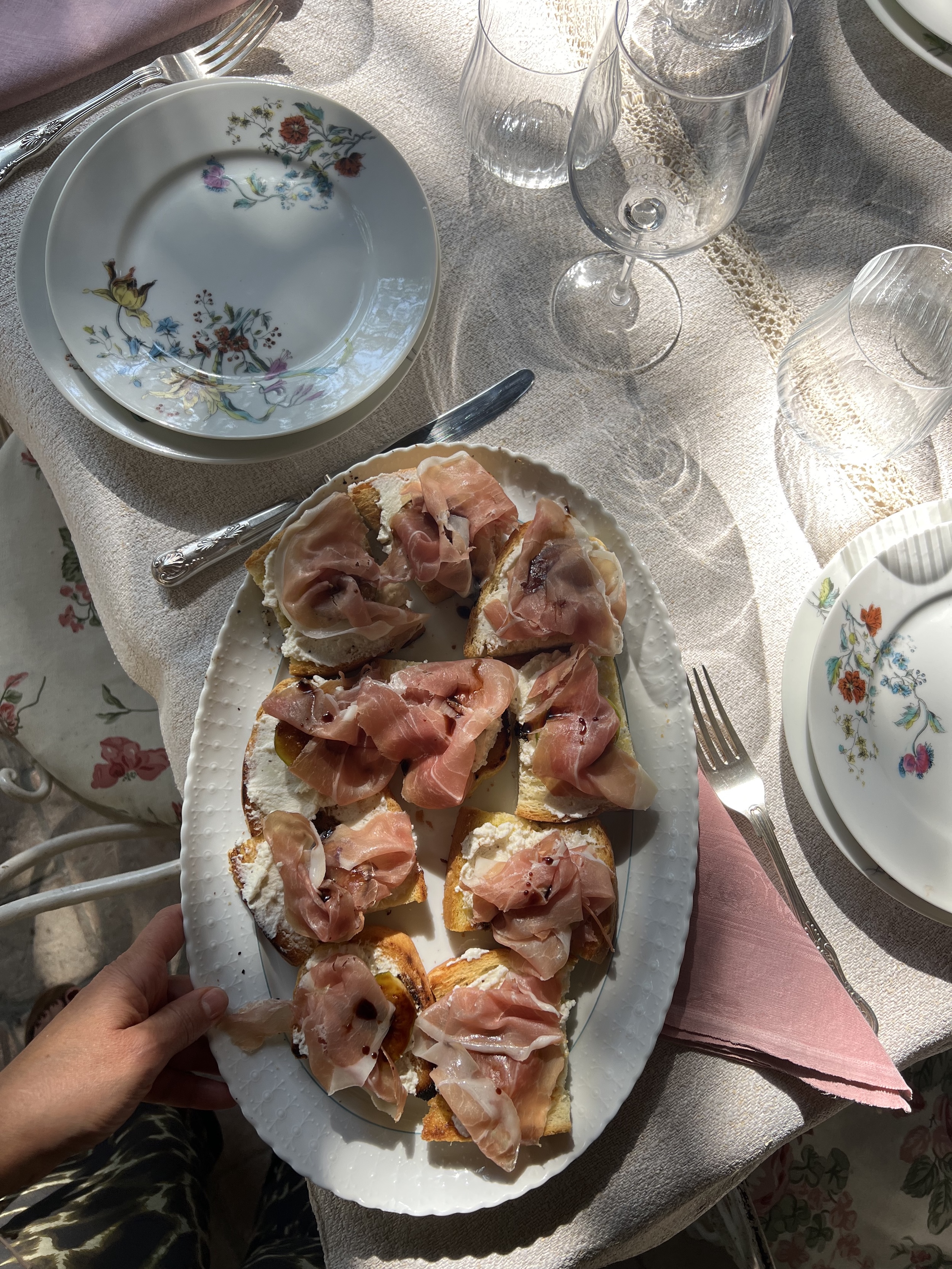 Bruschetta with ricotta and prosciutto on rustic bread, served during a relaxed Italian countryside cooking session.
