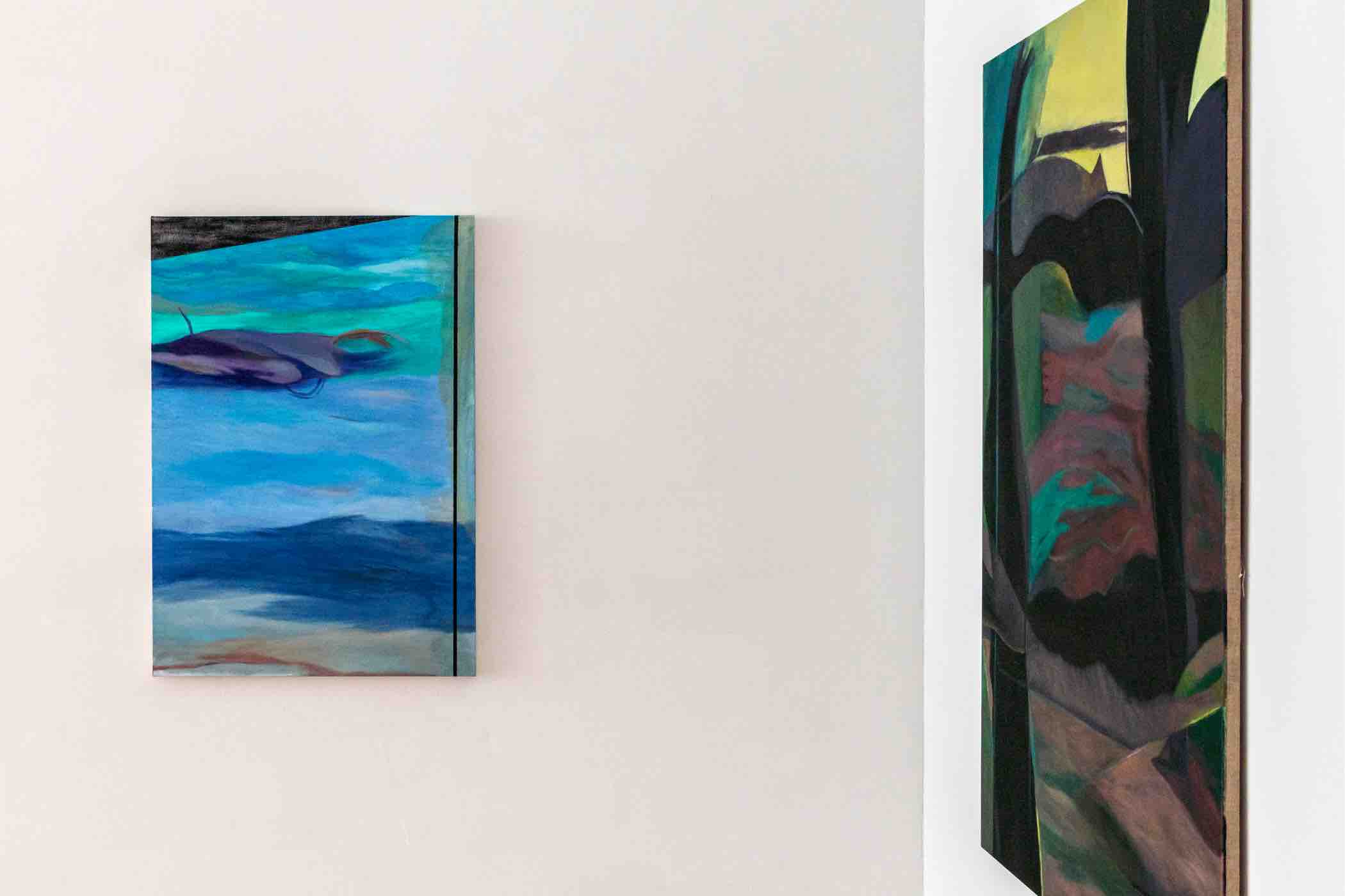 Two abstract paintings displayed on adjacent white walls, one with blue and purple hues and the other with dark green, pink, and black tones.