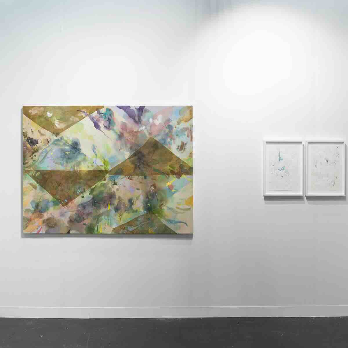 Gallery wall with one large abstract painting featuring geometric shapes and soft, blended colors, next to two small framed abstract sketches in white frames.