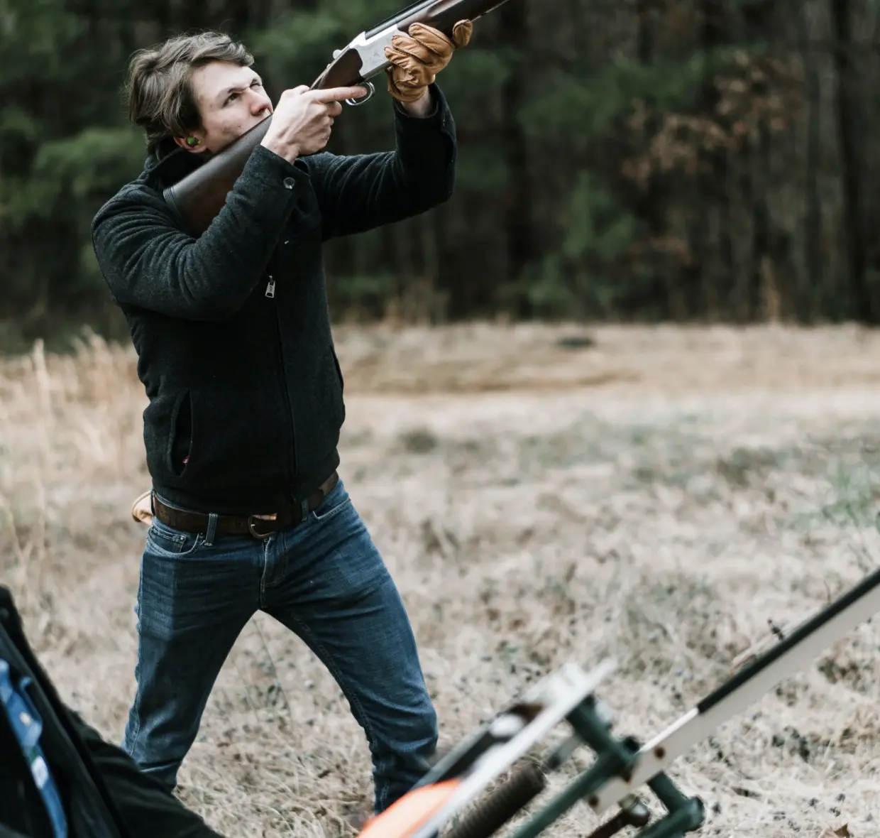 man clay pigeon shooting with earplugs