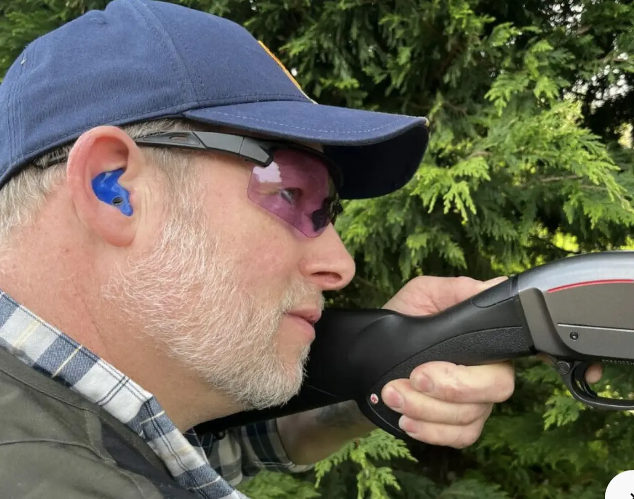 man shooting wearing earplugs
