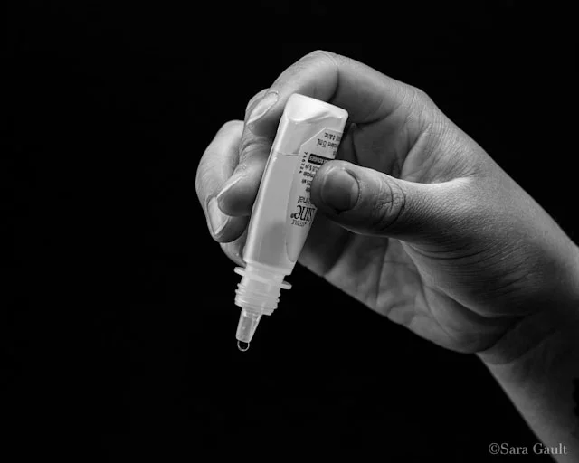 human hand holding ear drops bottle