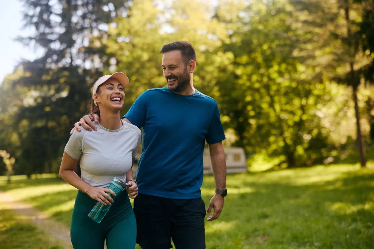 Active couple walking outdoors together, representing a daily exercise routine for men, healthy lifestyle habits, and ways to improve sexual performance naturally.