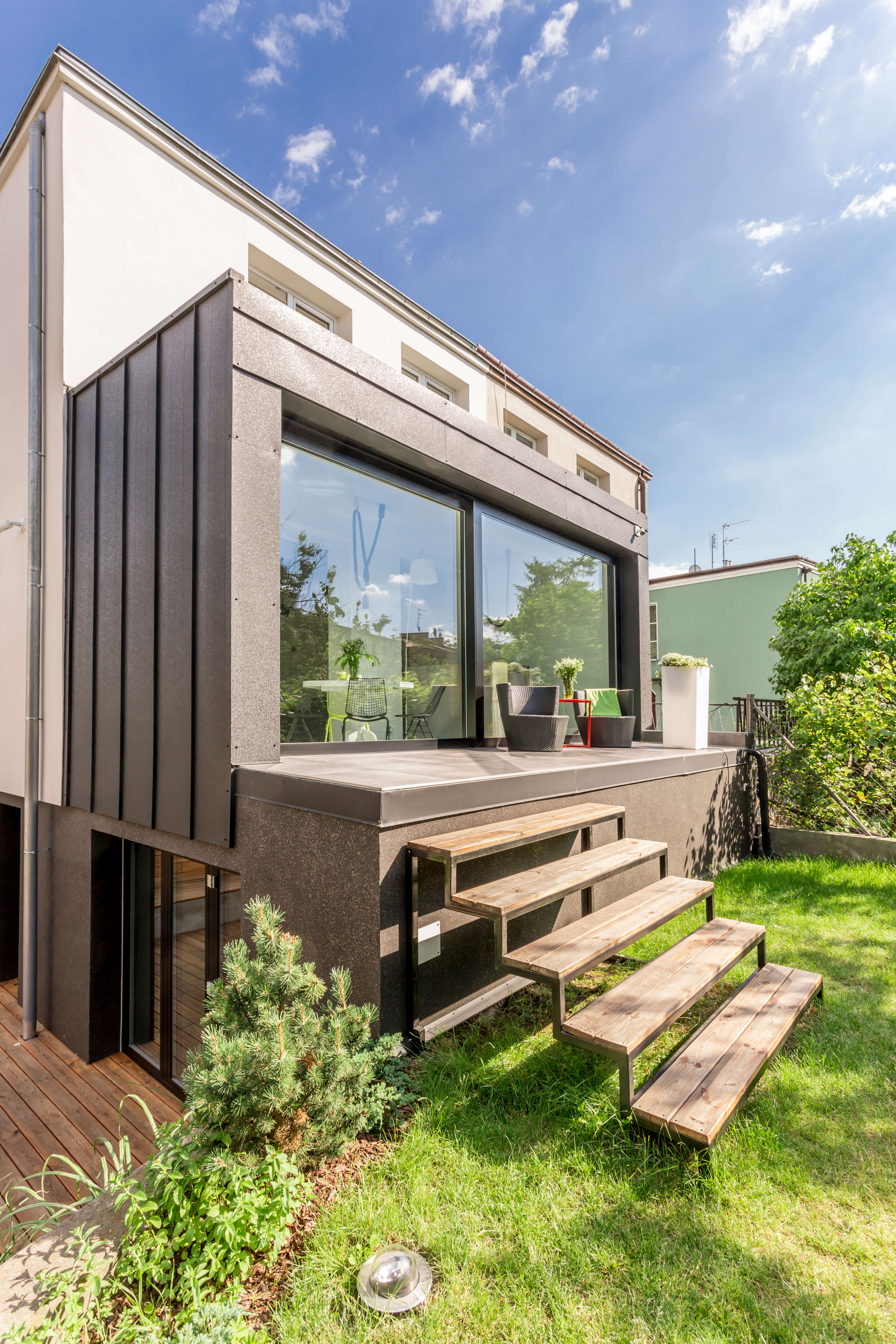 Compact gray backyard ADU with French doors, vertical windows, and organized interior storage space.