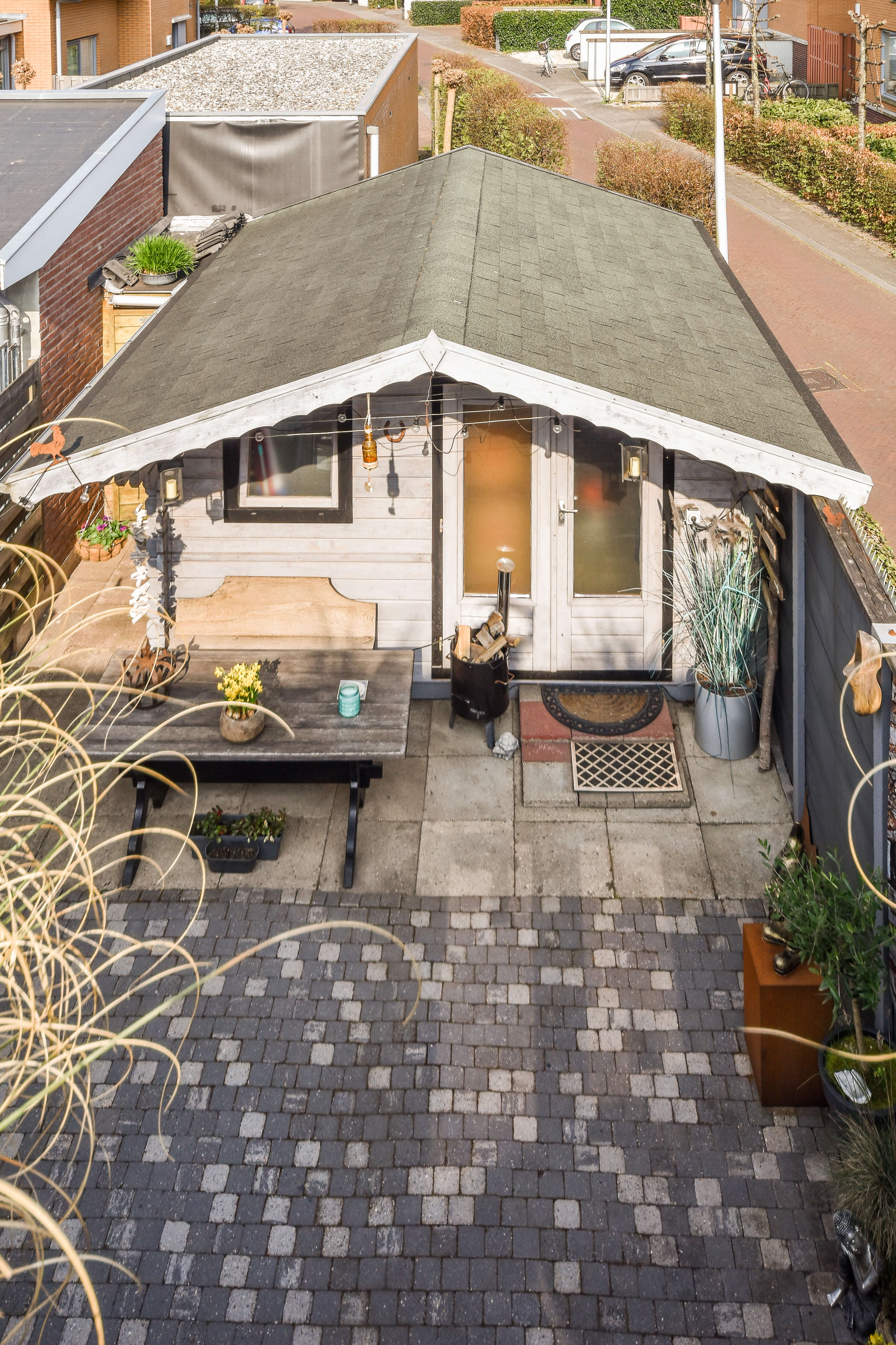 Spacious backyard ADU with dark siding, open patio, and a landscaped yard with outdoor seating.