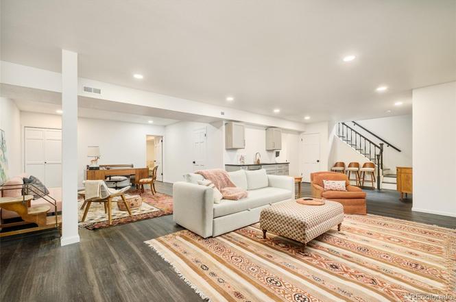 Finished basement remodel with open layout, cozy seating area, and modern lighting.