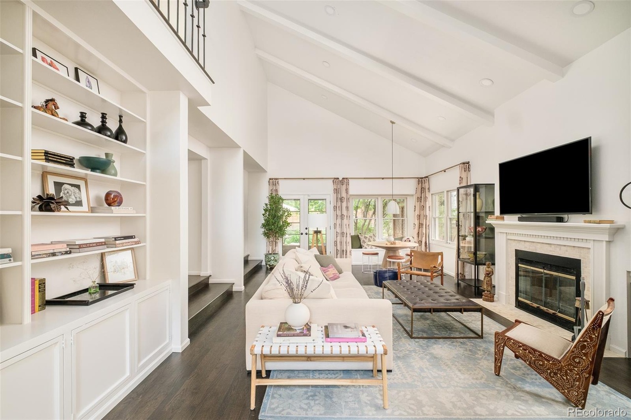 Living room of a Hilltop Denver home remodel with vaulted ceilings, white walls, and open shelving design.