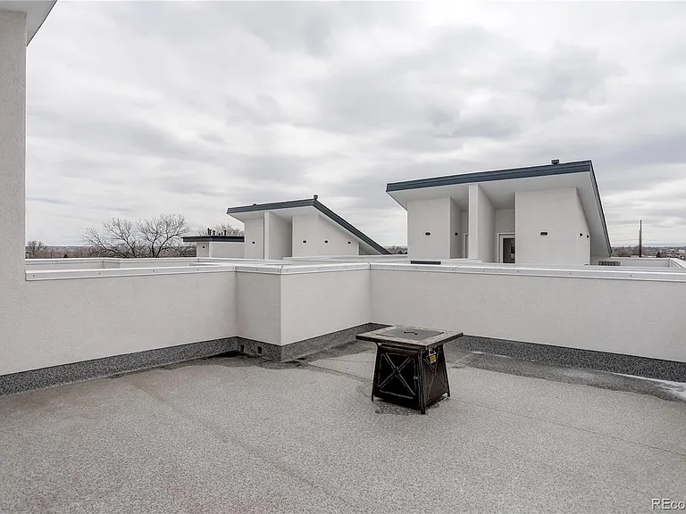 Rooftop patio with textured flooring and skyline views, ideal for hosting or lounging