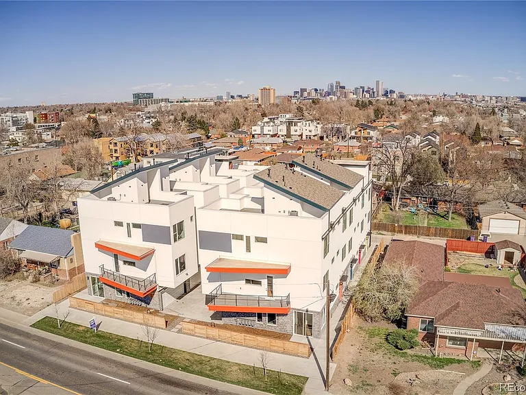 Drone view of multi-unit property with parking and landscaping in urban Denver