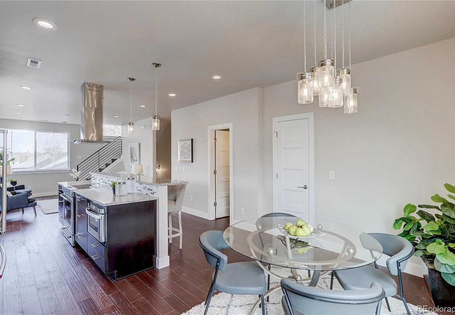 Dining room with circular table and modern chandelier in open floor plan