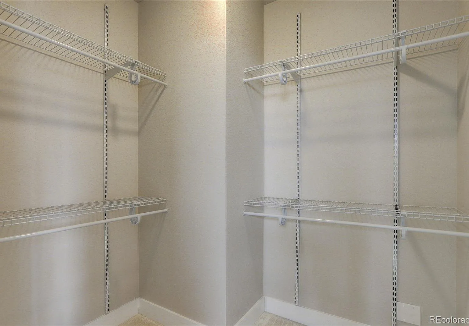 Walk-in closet with built-in shelving and overhead lighting