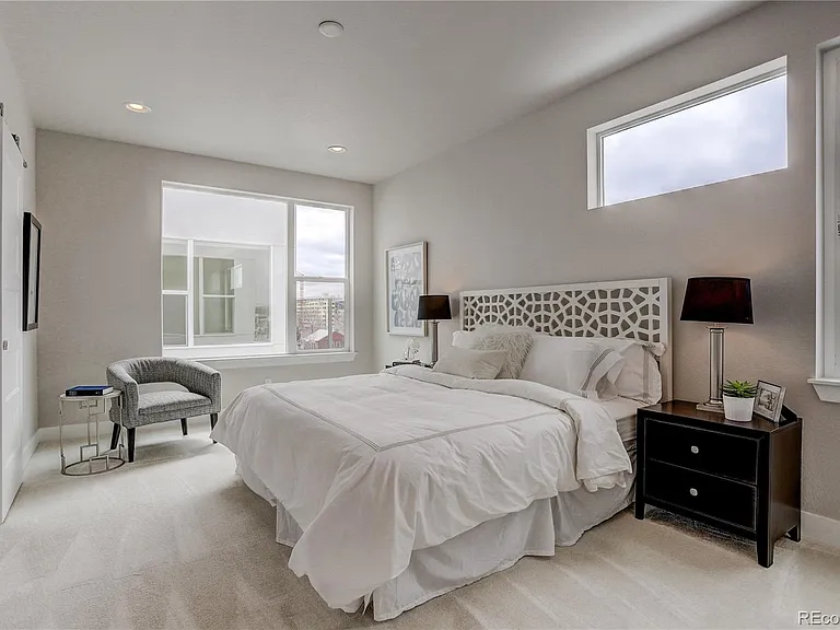 Primary bedroom with plush carpeting, modern furnishings, and mountain views