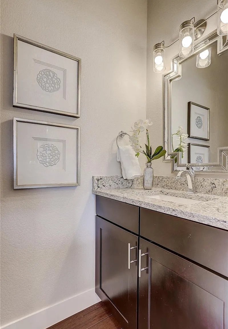 Guest bathroom with wall-mounted mirror, single vanity, and modern light fixture